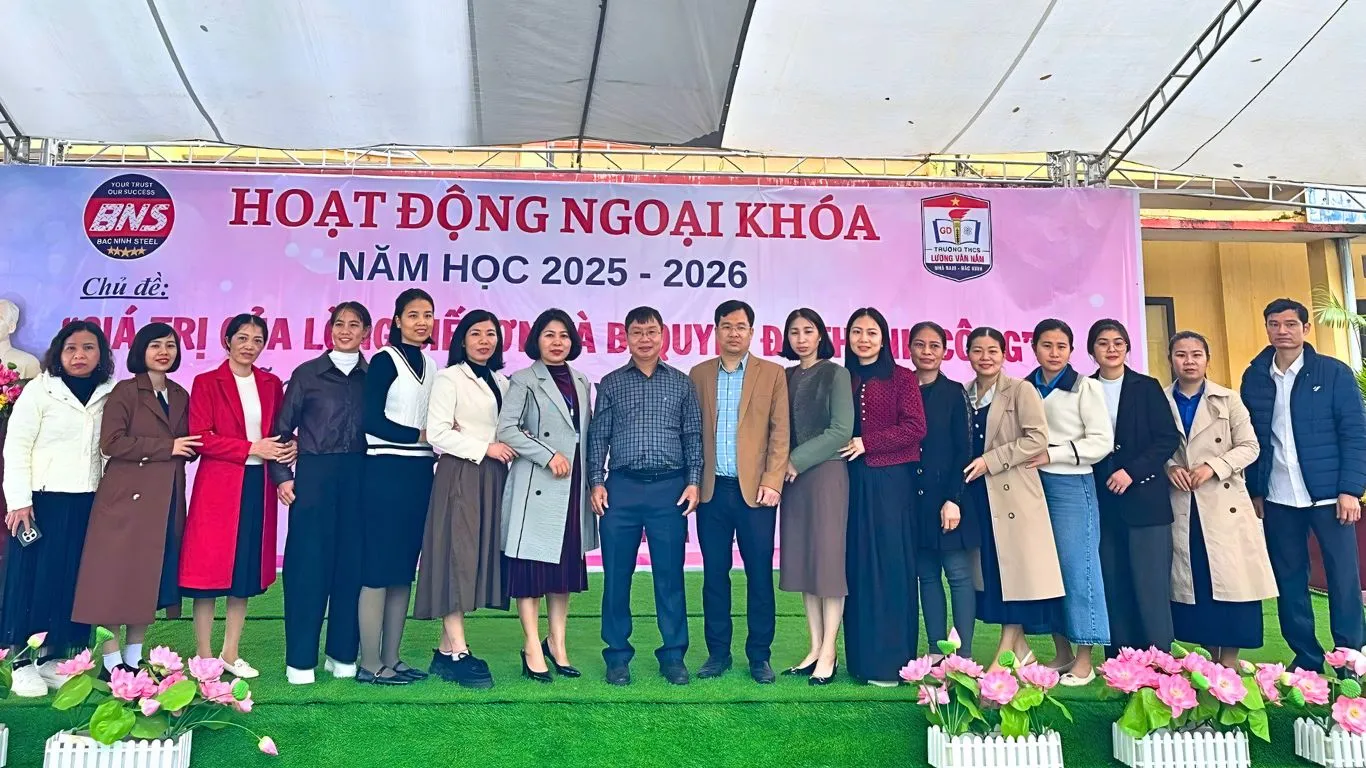 Tiến sĩ Nguyễn Thành Nhân chụp hình cùng thầy cô và phụ huynh trường THCS Lương Văn Nắm